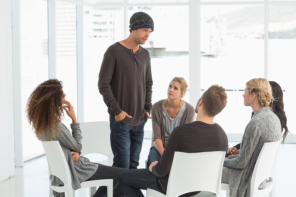 Group sitting around talking of men and women