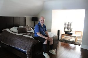 Individual with down syndrome sitting in his room in a CILA home.