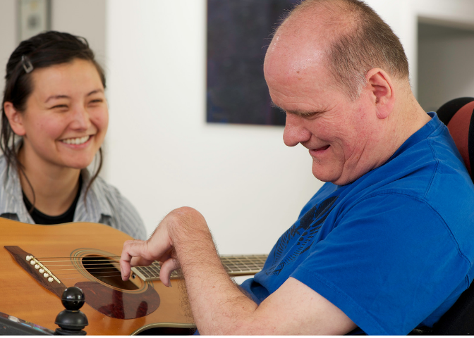 Staff member laughing with individual with a developmental disability.