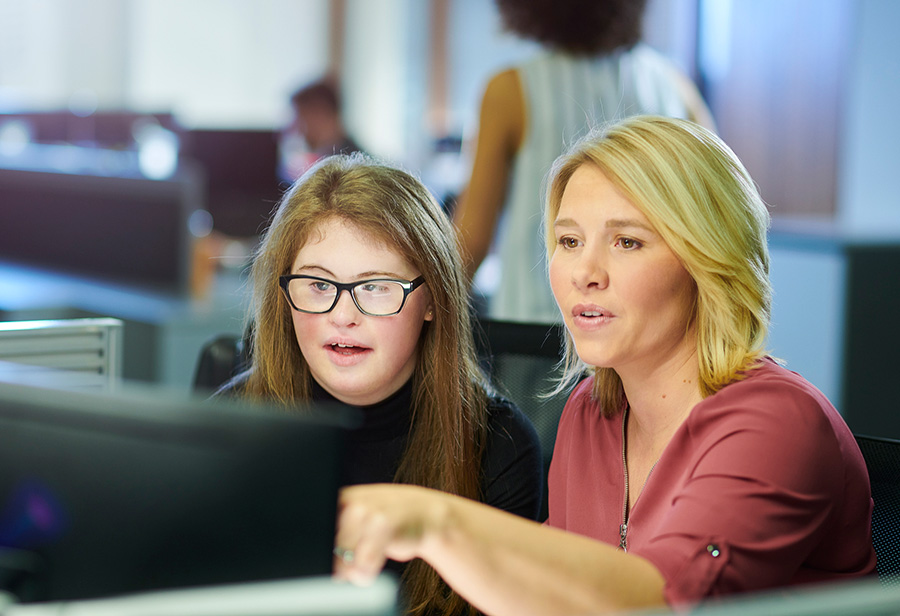 Young woman with down syndrome at work with mentor