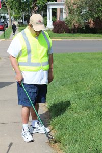 Man helping pick up trash from the sidewalk